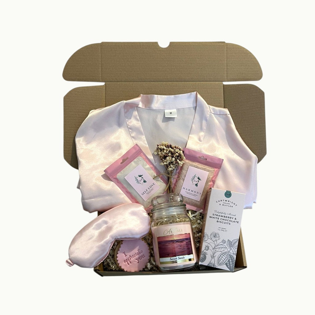A little moment for you gift box with robe, sleep mask, bath soaks and biscuits arranged in a self care hamper