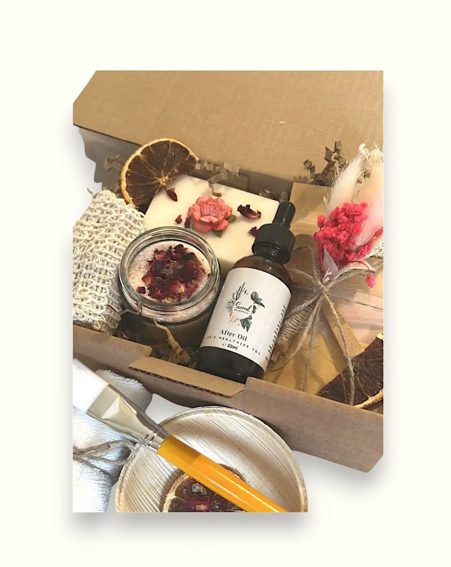 Christmas personalised natural skincare gifts including a jar of rose petal bath salts, a bottle of after oil, an exfoliating soap bag, and other skincare products with decorative elements like dried flowers and a natural towel.