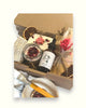 Christmas personalised natural skincare gifts including a jar of rose petal bath salts, a bottle of after oil, an exfoliating soap bag, and other skincare products with decorative elements like dried flowers and a natural towel.