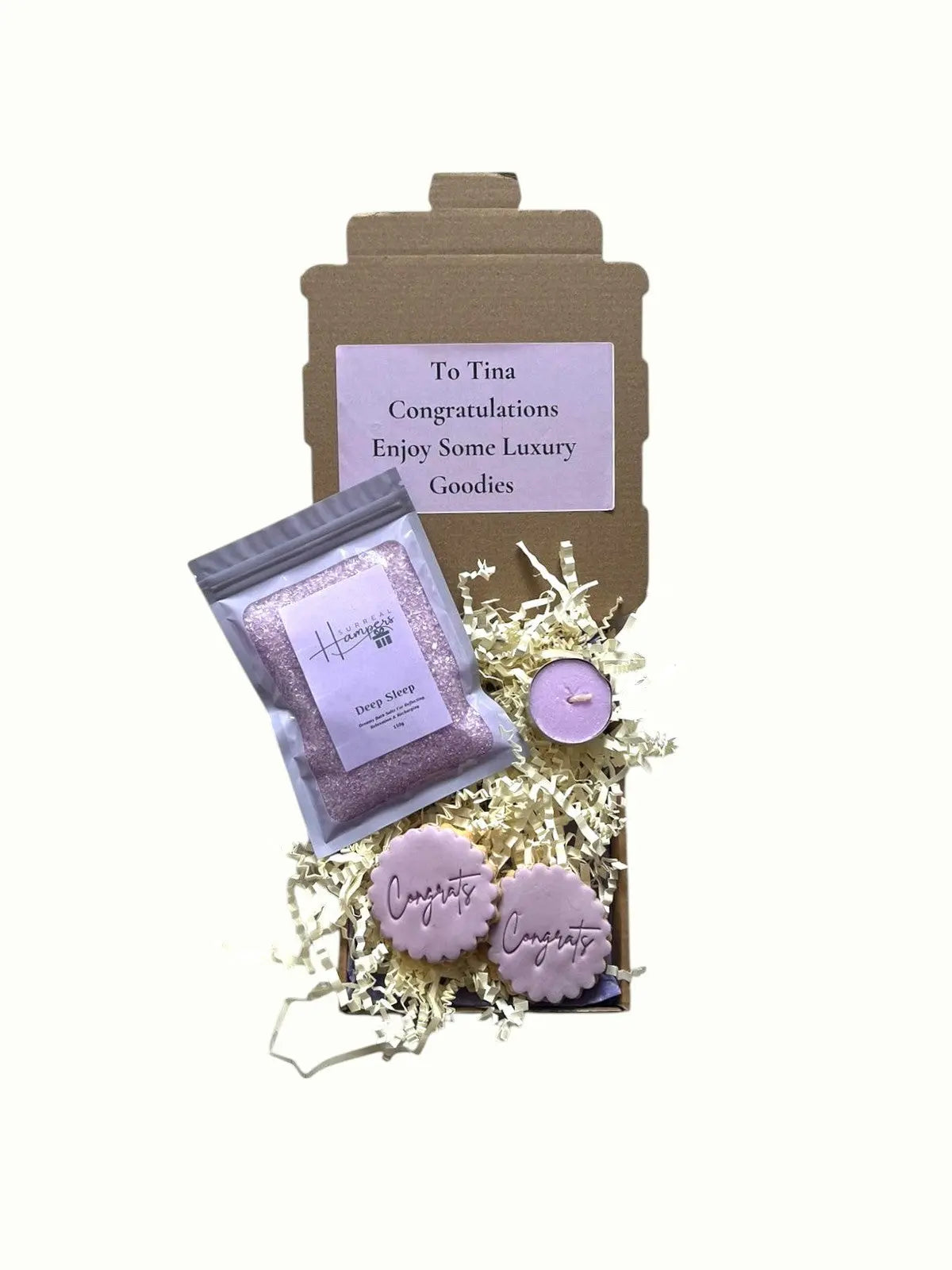 Gift set with lavender-themed products including a bag, soap, and candle, with a personalized card on a white background.