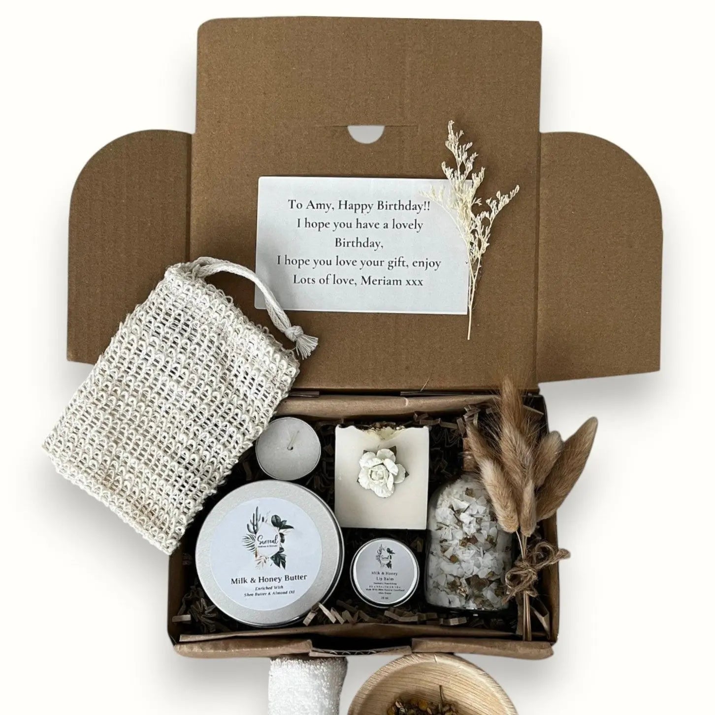 Christmas gift box with free next day delivery including natural skincare and festive treat. Box includes a candle, a lip balm, a soap bar, and other skincare products.