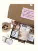 Gift set with candles, soap, and a card in an open box with a personalized message. Surreal Hampers UK